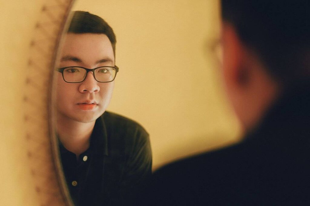 person looking at reflection thoughtfully showing self examination needed to learn how to deal with jealousy