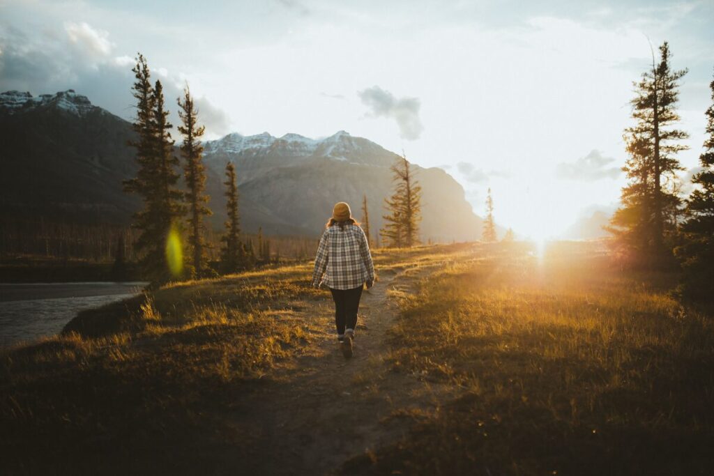 person walking calmly at sunrise, the result of learning how to stop being a people pleaser